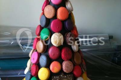 Fontaine à chocolat sur une table de buffet avec des fruits frais et des brochettes en arrière-plan.