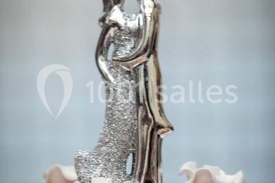 Fontaine à chocolat sur une table de buffet avec des fruits frais et des brochettes en arrière-plan.