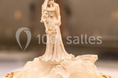 Fontaine à chocolat sur une table de buffet avec des fruits frais et des brochettes en arrière-plan.