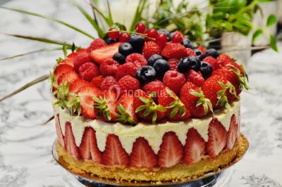 Fontaine à chocolat sur une table de buffet avec des fruits frais et des brochettes en arrière-plan.