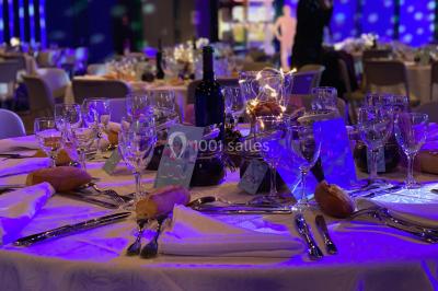 Fontaine à chocolat sur une table de buffet avec des fruits frais et des brochettes en arrière-plan.