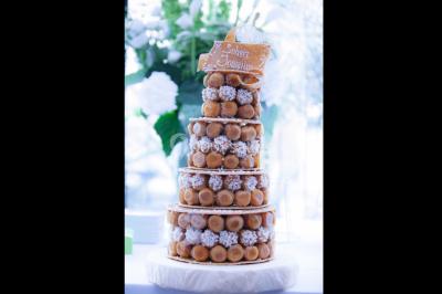 Fontaine à chocolat sur une table de buffet avec des fruits frais et des brochettes en arrière-plan.