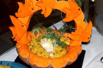Gâteau au chocolat décoré de framboises et d'une fleur rose, présenté sur un plateau sombre.