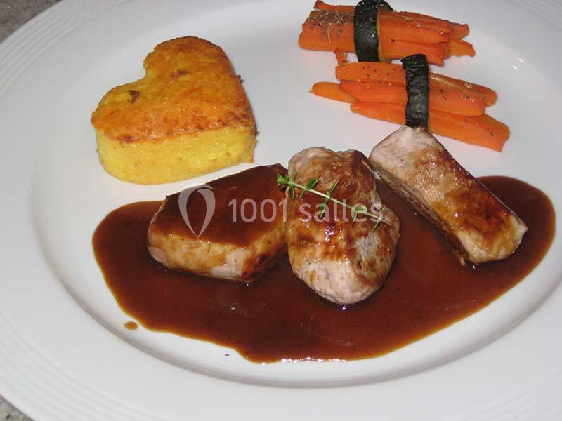 Assiette avec filet de viande nappé de sauce, flan en forme de cœur et carottes liées par des bandes d'algues.
