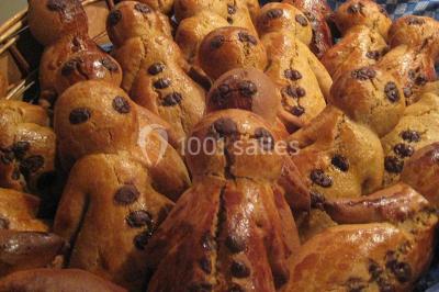 Des bonshommes en brioche dorée avec des pépites de chocolat, disposés dans un panier en osier.