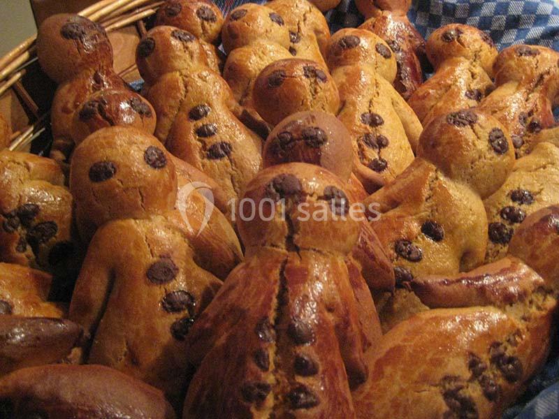 Des bonshommes en brioche dorée avec des pépites de chocolat, disposés dans un panier en osier.