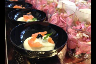Plateau à étages avec des coquilles garnies de crevettes, légumes et herbes, présenté sur une table de buffet.