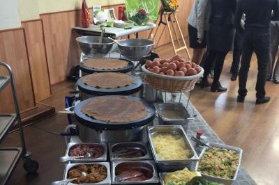Plateau à étages avec des coquilles garnies de crevettes, légumes et herbes, présenté sur une table de buffet.