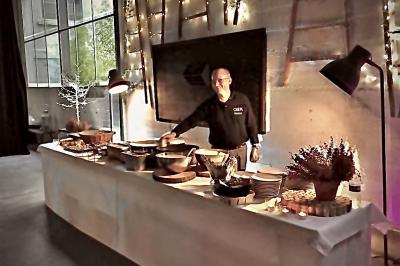 Plateau à étages avec des coquilles garnies de crevettes, légumes et herbes, présenté sur une table de buffet.