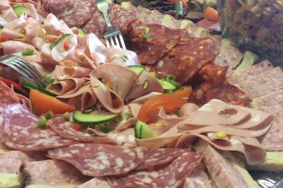 Plateau à étages avec des coquilles garnies de crevettes, légumes et herbes, présenté sur une table de buffet.