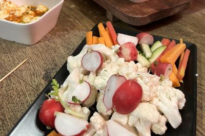 Plateau à étages avec des coquilles garnies de crevettes, légumes et herbes, présenté sur une table de buffet.