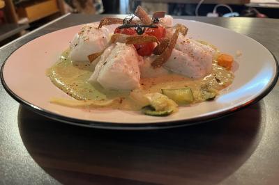 Plateau à étages avec des coquilles garnies de crevettes, légumes et herbes, présenté sur une table de buffet.