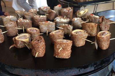 Plateau à étages avec des coquilles garnies de crevettes, légumes et herbes, présenté sur une table de buffet.