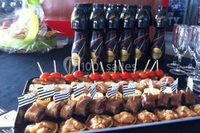 Plateau à étages avec des coquilles garnies de crevettes, légumes et herbes, présenté sur une table de buffet.