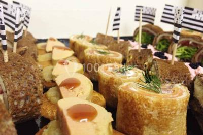 Plateau à étages avec des coquilles garnies de crevettes, légumes et herbes, présenté sur une table de buffet.