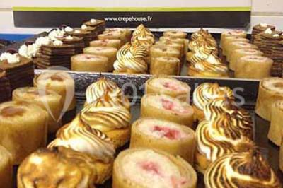 Plateau à étages avec des coquilles garnies de crevettes, légumes et herbes, présenté sur une table de buffet.