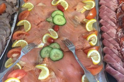 Plateau à étages avec des coquilles garnies de crevettes, légumes et herbes, présenté sur une table de buffet.