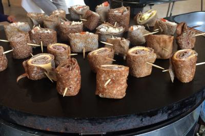 Plateau à étages avec des coquilles garnies de crevettes, légumes et herbes, présenté sur une table de buffet.