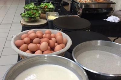 Plateau à étages avec des coquilles garnies de crevettes, légumes et herbes, présenté sur une table de buffet.