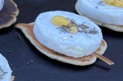 Plateau à étages avec des coquilles garnies de crevettes, légumes et herbes, présenté sur une table de buffet.