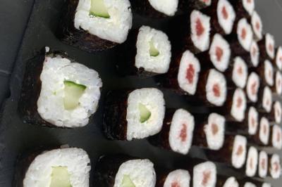 Plateau de mini-burgers colorés et assortiments de canapés sur une table dressée pour un buffet.