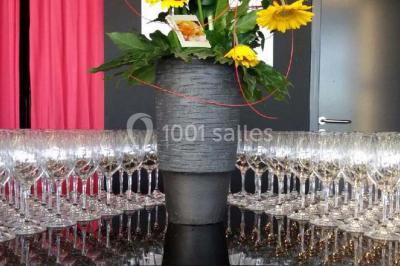 Plateau de mini-burgers colorés et assortiments de canapés sur une table dressée pour un buffet.