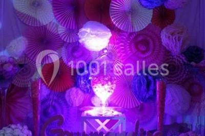 Plateau de mini-burgers colorés et assortiments de canapés sur une table dressée pour un buffet.