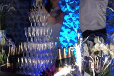 Table décorée avec des desserts et des éléments rustiques dans une salle avec éclairage tamisé et lanternes suspendues.