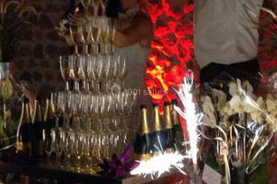 Table décorée avec des desserts et des éléments rustiques dans une salle avec éclairage tamisé et lanternes suspendues.