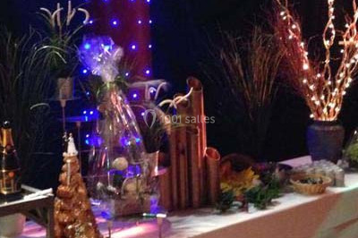 Table décorée avec des desserts et des éléments rustiques dans une salle avec éclairage tamisé et lanternes suspendues.