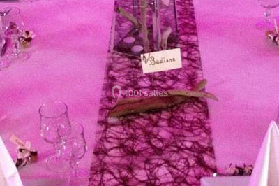 Table décorée avec des desserts et des éléments rustiques dans une salle avec éclairage tamisé et lanternes suspendues.