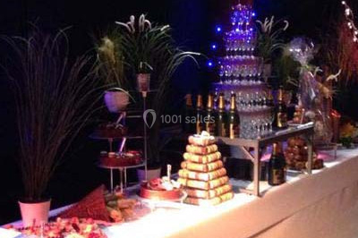 Table décorée avec des desserts et des éléments rustiques dans une salle avec éclairage tamisé et lanternes suspendues.