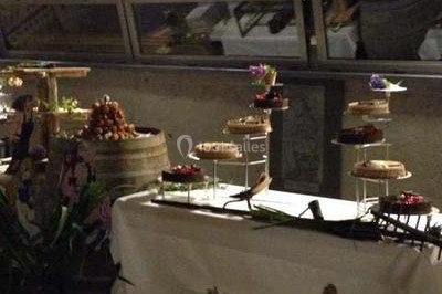 Table décorée avec des desserts et des éléments rustiques dans une salle avec éclairage tamisé et lanternes suspendues.