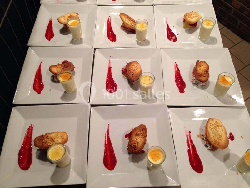 Assiettes dressées avec un dessert composé de verrines, pâtisseries et coulis rouge disposé en trait.