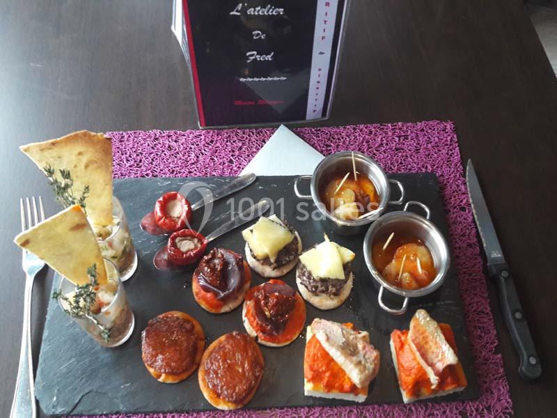 Plateau d'amuse-bouches variés sur une ardoise, comprenant mini-brochettes, toasts, verrines et petits plats.