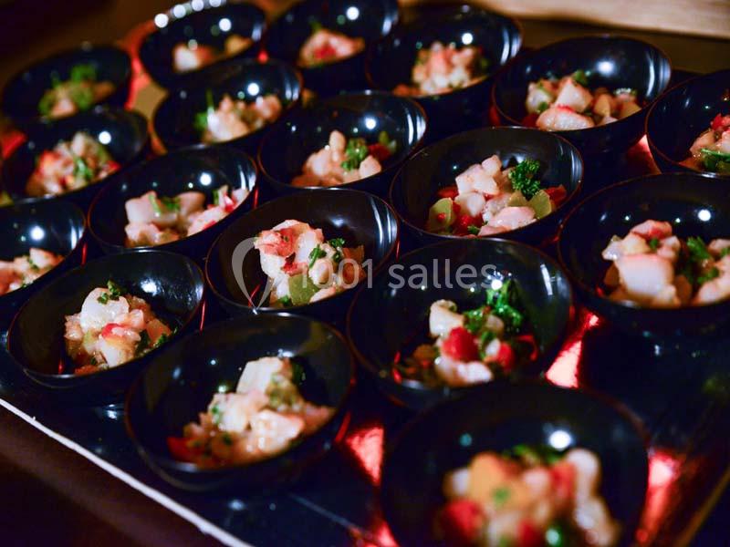 Petits bols noirs contenant des portions de ceviche coloré avec des morceaux de poisson, légumes et herbes fraîches.