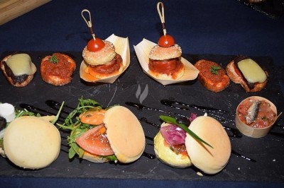 Miniature Traiteur La Chapelle-d'Armentières (Nord) - L'Atelier de Fred #41 Plateau de mini-burgers, bouchées variées et garnitures sur une ardoise noire, présenté sur une nappe sombre.
