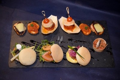 Miniature Traiteur La Chapelle-d'Armentières (Nord) - L'Atelier de Fred #42 Plateau de mini-burgers, bouchées variées et garnitures sur une ardoise noire, présenté sur une nappe sombre.