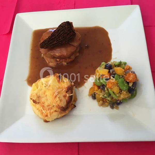 Assiette composée d'une viande en sauce, d'un gratin individuel et d'une salade colorée de légumes.