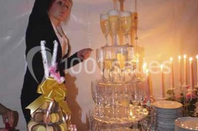 Table dressée pour un mariage avec nappe blanche, chemin de table fuchsia, pliage de serviette et décorations festives.