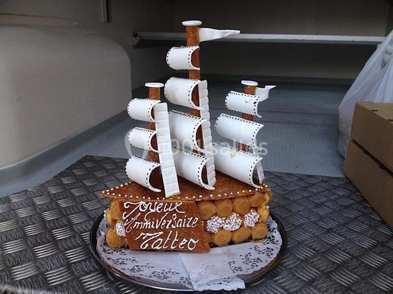 Pièce montée en forme de voilier avec voiles en sucre et inscription ’Joyeux Anniversaire Matteo’.