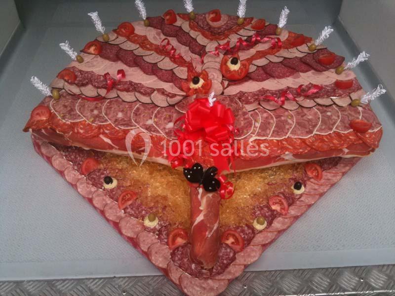 Plateau décoratif en forme de paon composé de charcuteries variées, fruits et légumes pour la garniture.