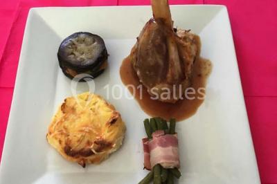 Table dressée pour un mariage avec nappe blanche, chemin de table fuchsia, pliage de serviette et décorations festives.