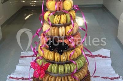 Table dressée pour un mariage avec nappe blanche, chemin de table fuchsia, pliage de serviette et décorations festives.