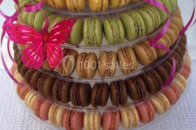 Table dressée pour un mariage avec nappe blanche, chemin de table fuchsia, pliage de serviette et décorations festives.