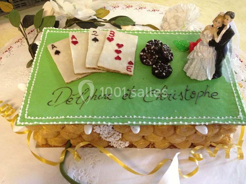 Gâteau de mariage décoré de cartes à jouer, jetons de poker et figurines de mariés, avec inscription personnalisée.