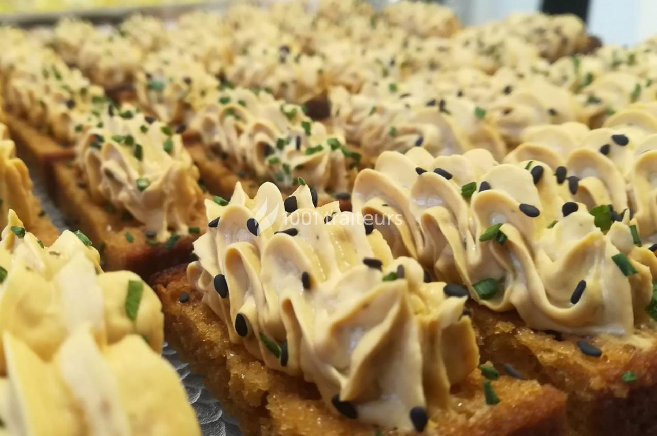 Tranches de pain grillé garnies de mousse crémeuse, parsemées de graines de sésame noir et de ciboulette.
