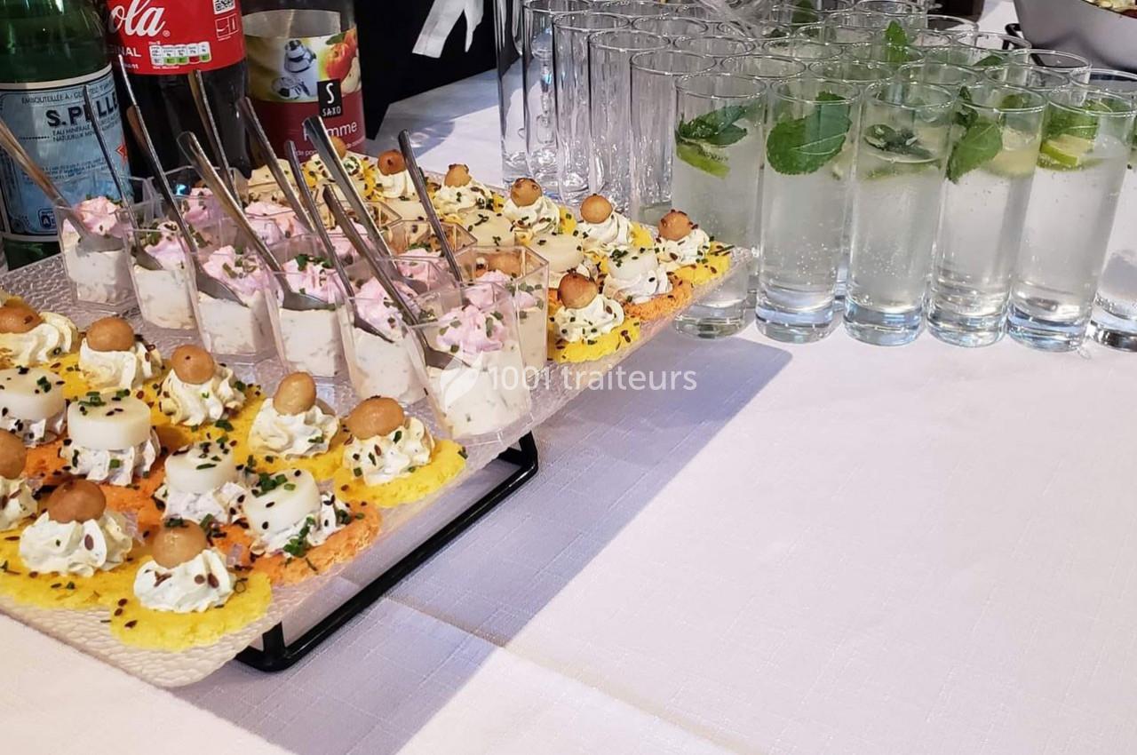 Plateau d'amuse-bouches variés et verres de cocktails garnis de feuilles de menthe et rondelles de citron.