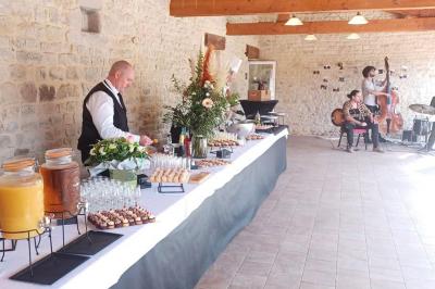 Buffet varié avec verrines, amuse-bouches, pains et pâtisseries disposés sur une table noire.