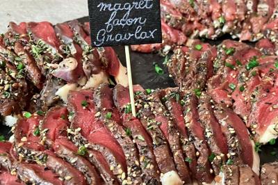 Table décorée pour un repas festif avec nappes blanches, verres, bougies, décorations végétales et petits cadeaux.